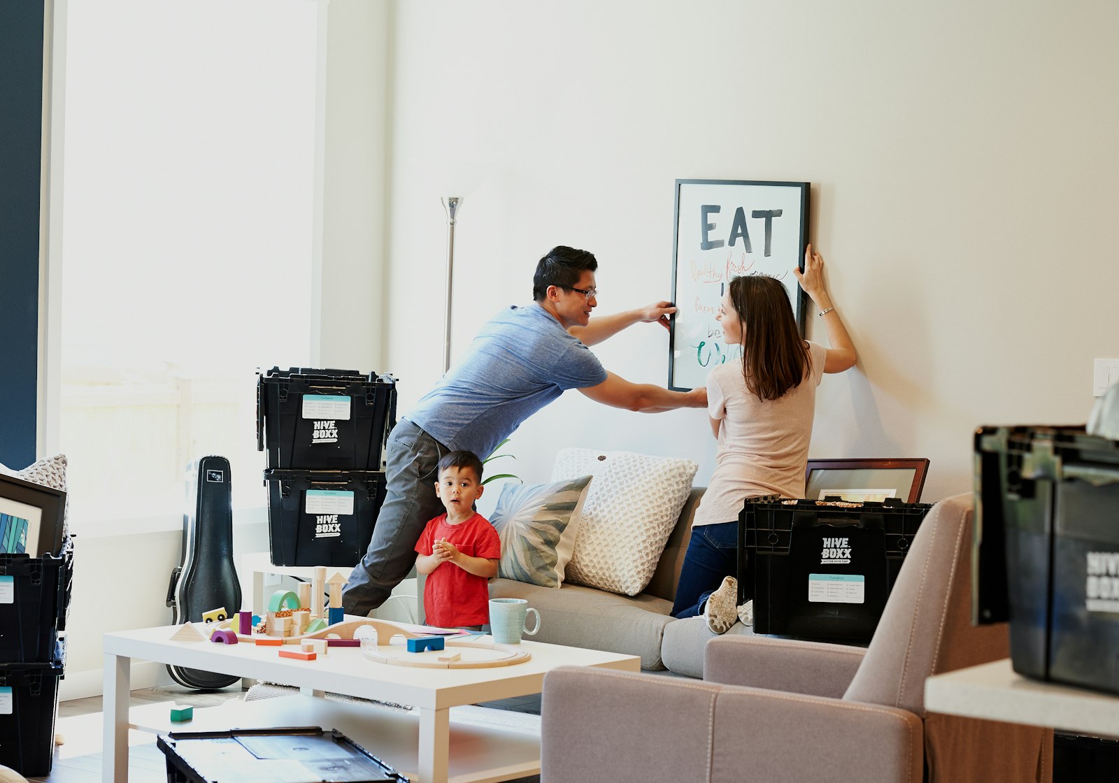 A family together on moving day, sharing a warm, hopeful moment among packed boxes